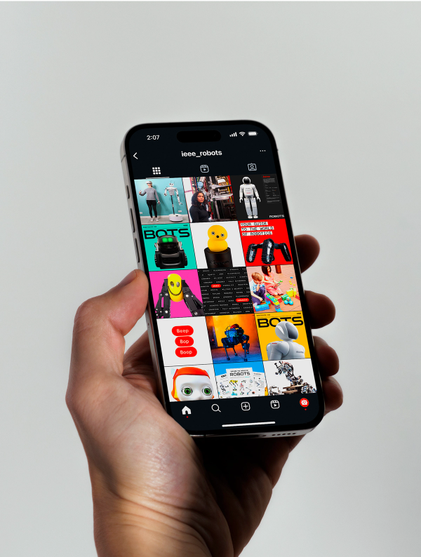 A hand holding an iPhone displaying an Instagram profile grid full of images of robots and other ROBOTS branded graphics