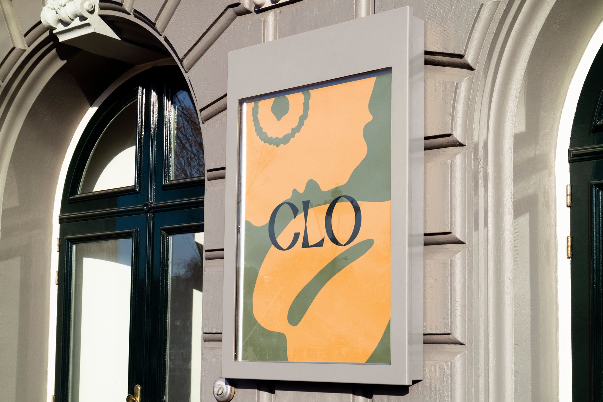 Poster on an exterior building wall of a flat flower illustration with the word "Clo" on top.